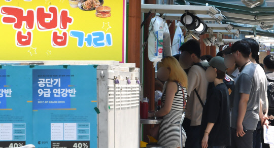 22일 오후서울 동작구 노량진 학원가에서 공무원 시험 준비생들이 노량진의 상징 컵밥집에서 점심 주문을 하기 위해 기다리고 있다. 연합뉴스